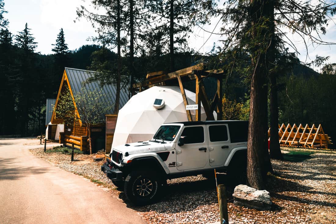 A vehicle parked at a trailhead with gear loaded on the roof