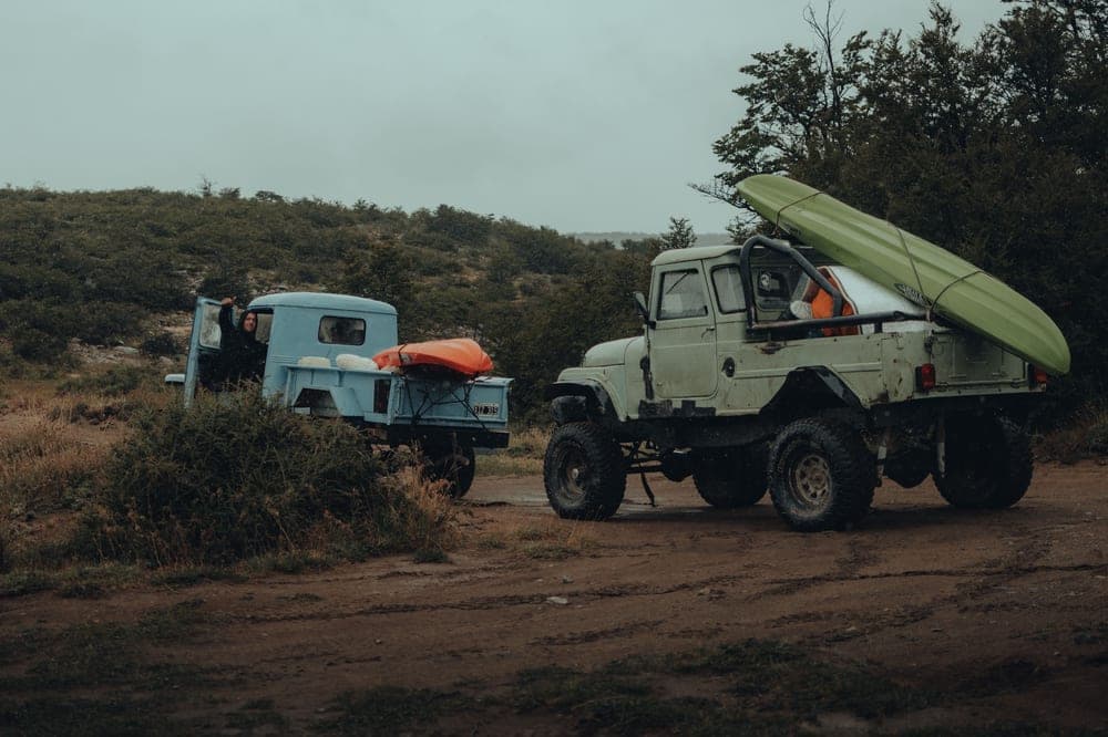 A kayak loaded in the bed of a pickup truck with the tailgate down