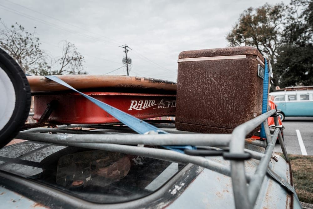 An open steel roof cargo basket loaded with outdoor gear