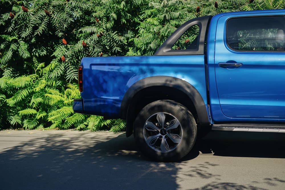 A mid-size pickup truck parked in a wooded clearing