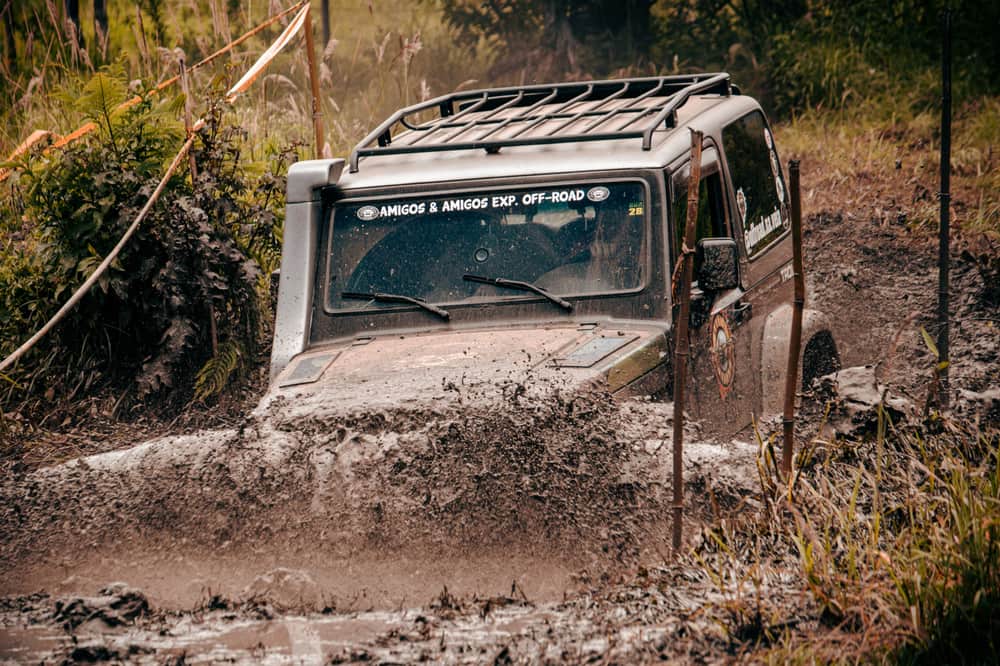 An off-road SUV with a removable hardtop parked on a rocky trail